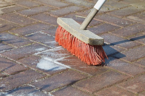 Cleaning patio with detergent and brush