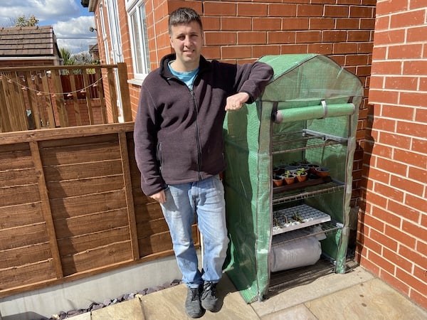 John standing next to a great example of a portable greenhouse