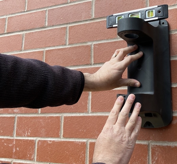 Checking bracket is level before marking holes for drilling