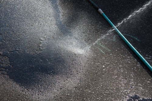 Cleaning tarmac driveway before applying a tarmac restorer