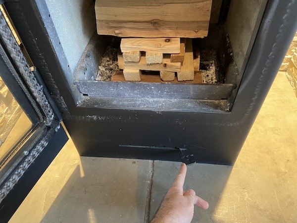 Making sure air vent on wood burning stove is fully open