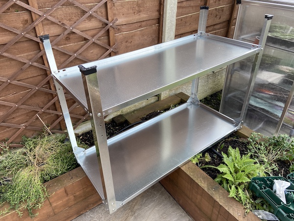 The final step of assembling the Palram Greenhouse Steel Work Bench  is attaching the bottom shelf