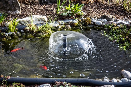 Pond fountain installed in small pond to help aerate the water